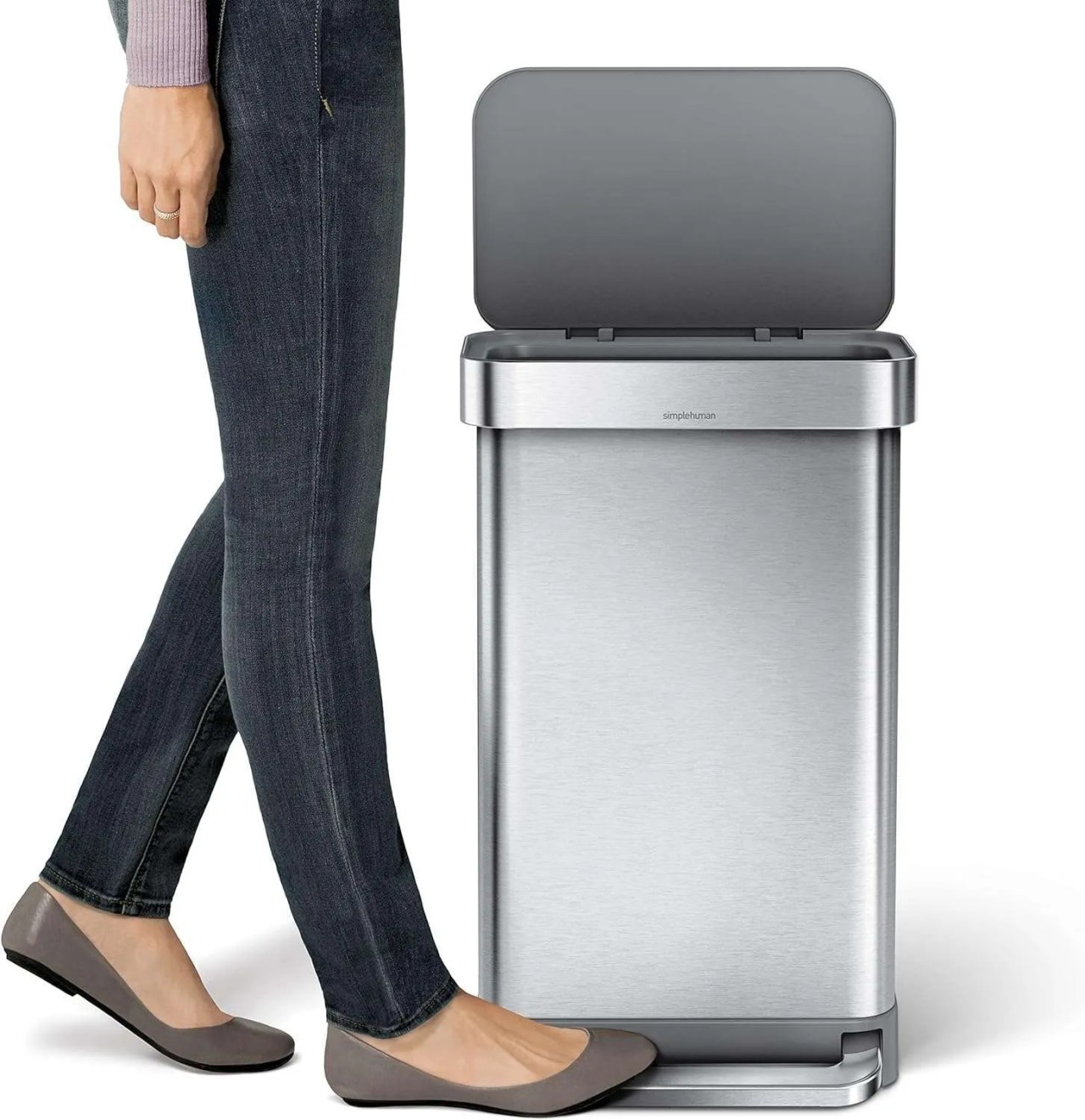 a woman using a foot pedal to open a bin