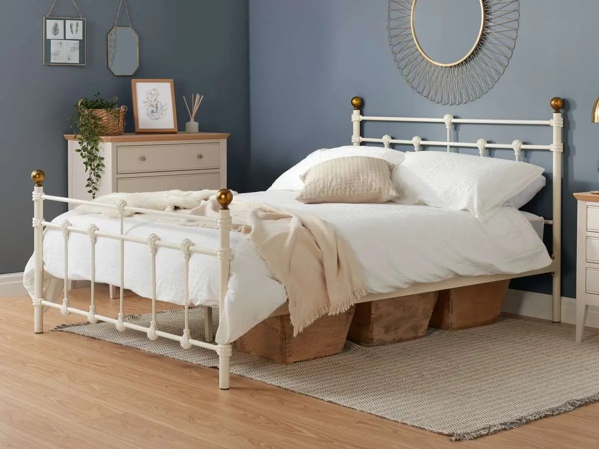 a white metal bed with blue walls