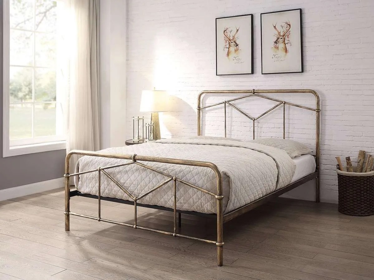 a brass art deco style bed with painted white brickwork