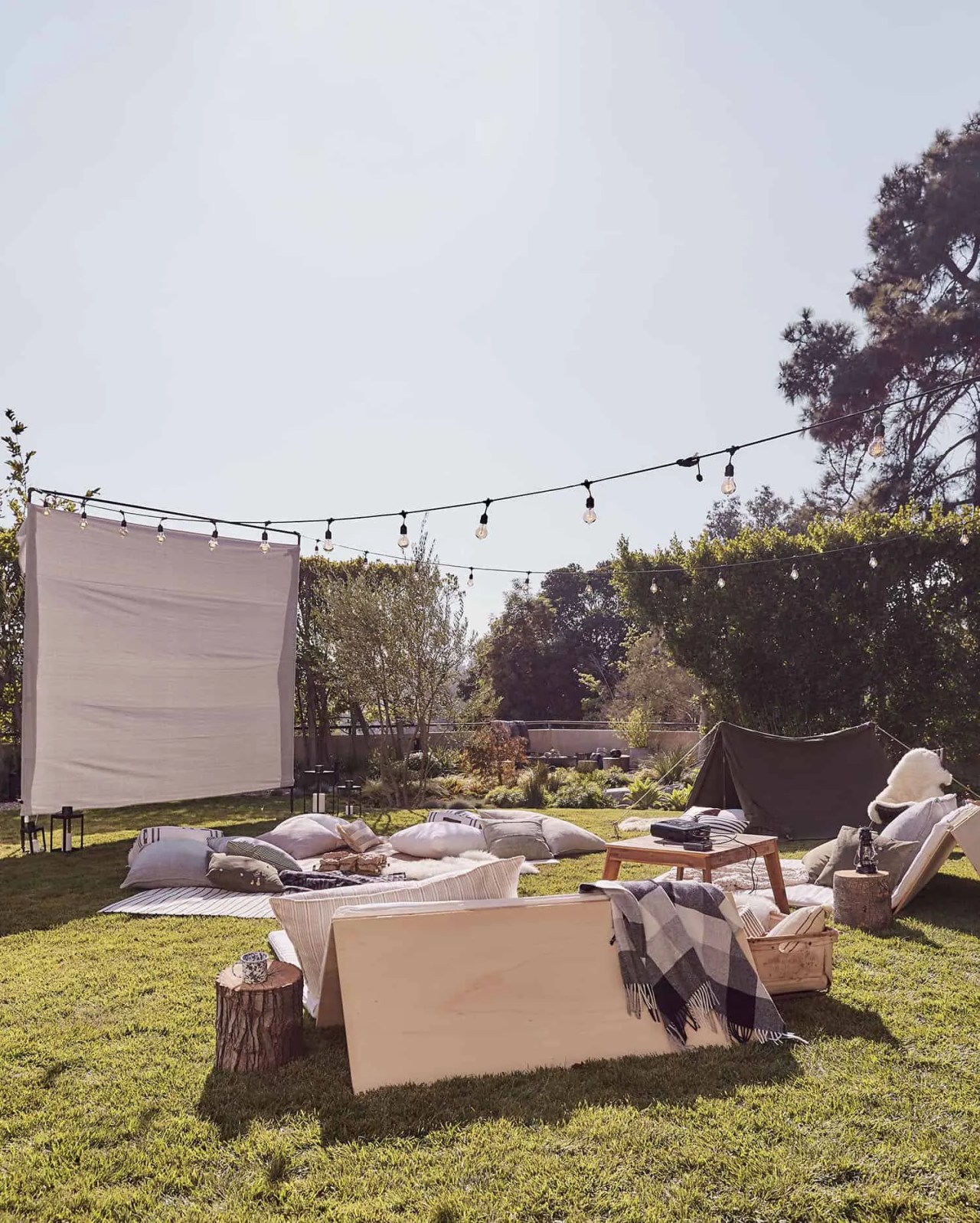 an outdoor cinema setup with lounge chairs and blankets. 