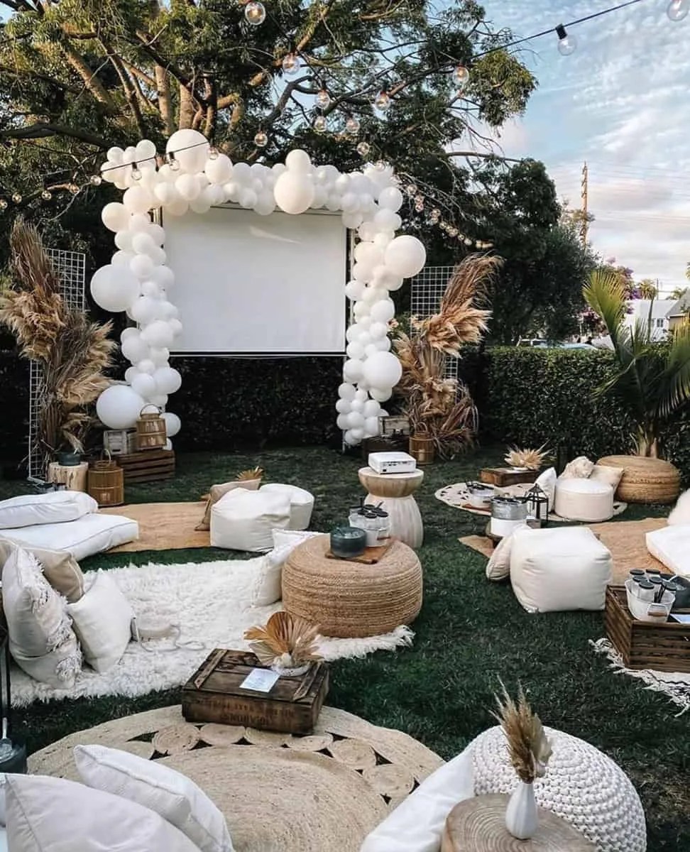 a boho setup in the garden with an outdoor cinema and lots of big balloons