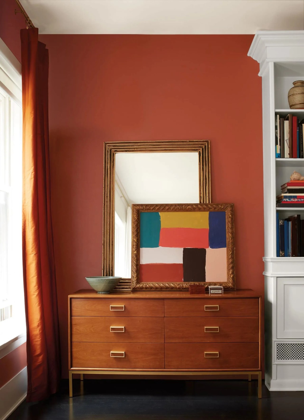 Benjamin Moore Cinnamon on the walls with mid century dresser and abstract art. 