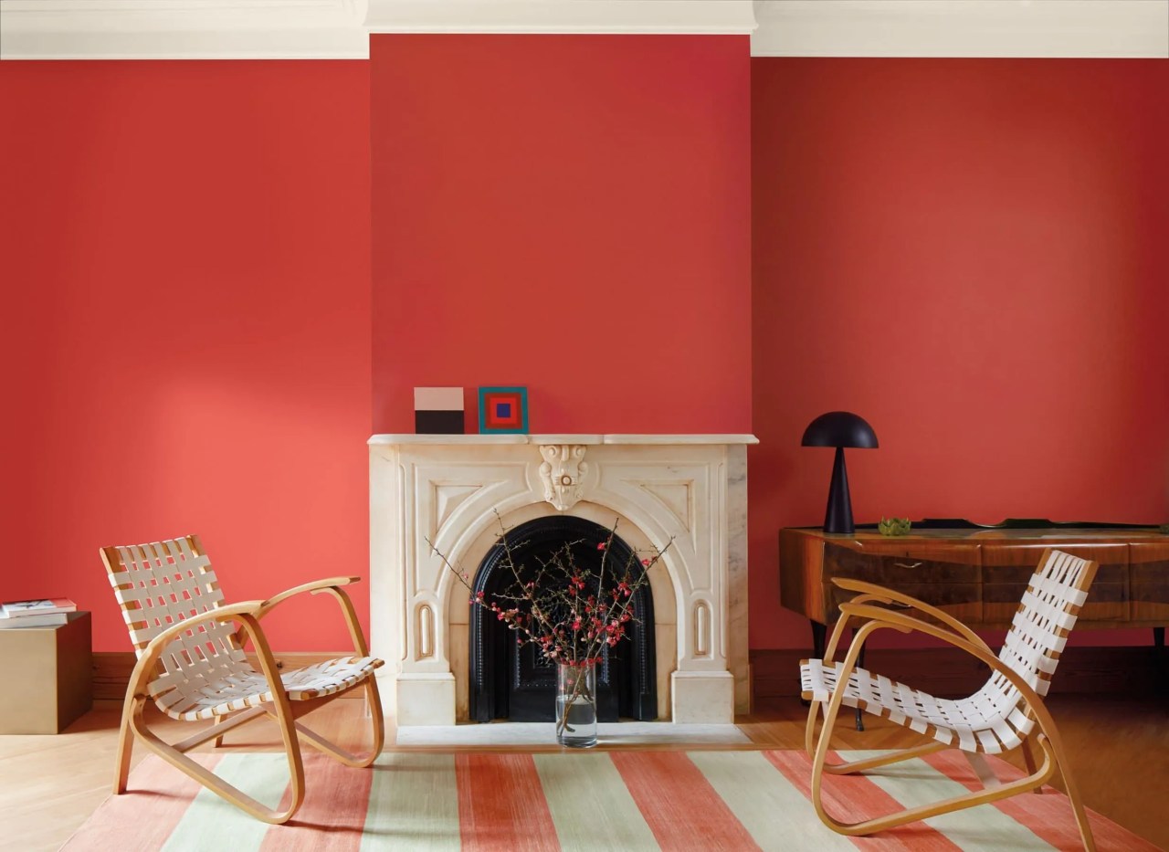 Benjamin Moore Raspberry Blush on the living room wall around a fireplace with a stripy rug