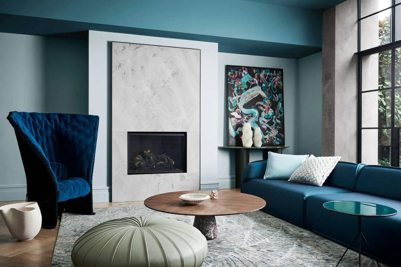 dark blue walls in the living room with a marble fireplace and arched doorway