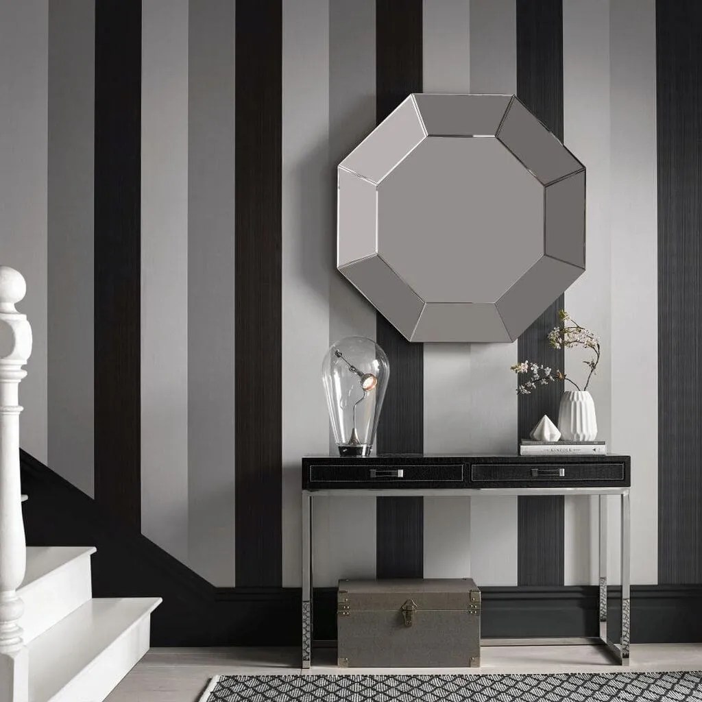 Black, grey and white striped wallpaper in the hallway with hexagonal silver mirror