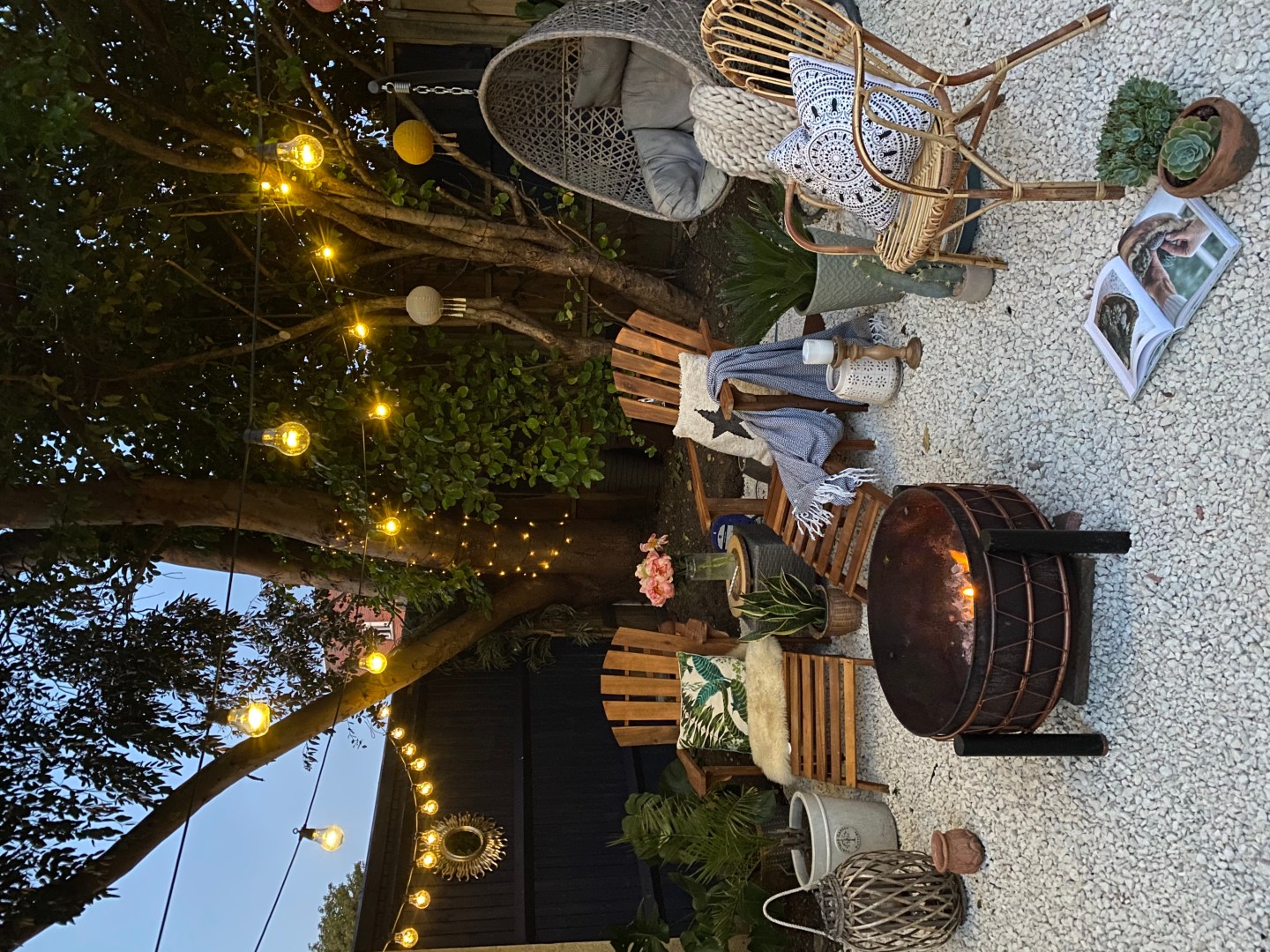 lighting and a fire pit on white gravel on a mediterranean inspired garden