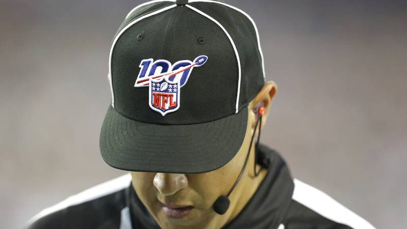 An official's cap shows the logo for the NFL's 100th anniversary in the second half of a...