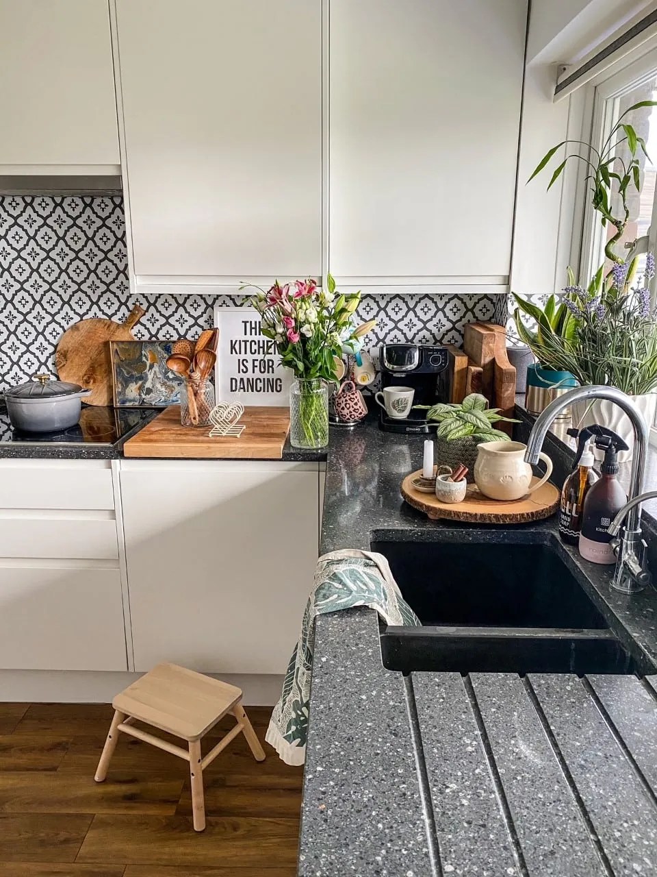 white gloss kitchen with karndean flooring and a granite worktop. There is peel and stick monochrome tile backsplash and a hob