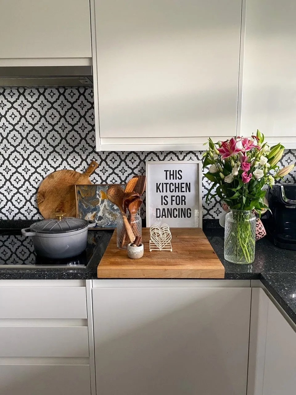 white gloss kitchen with karndean flooring and a granite worktop. There is a peel and stick tile backsplash and a hob