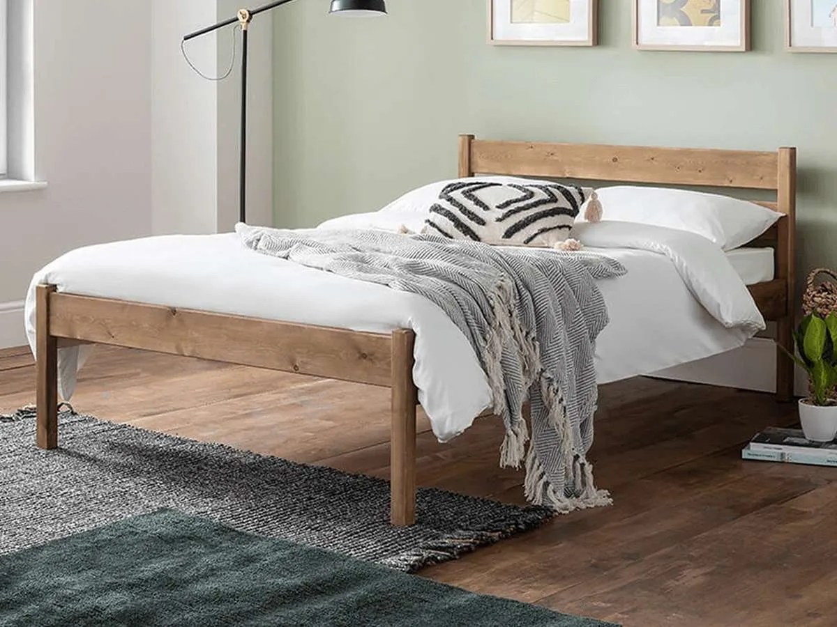 a wooden bed with sage green wall in the bedroom