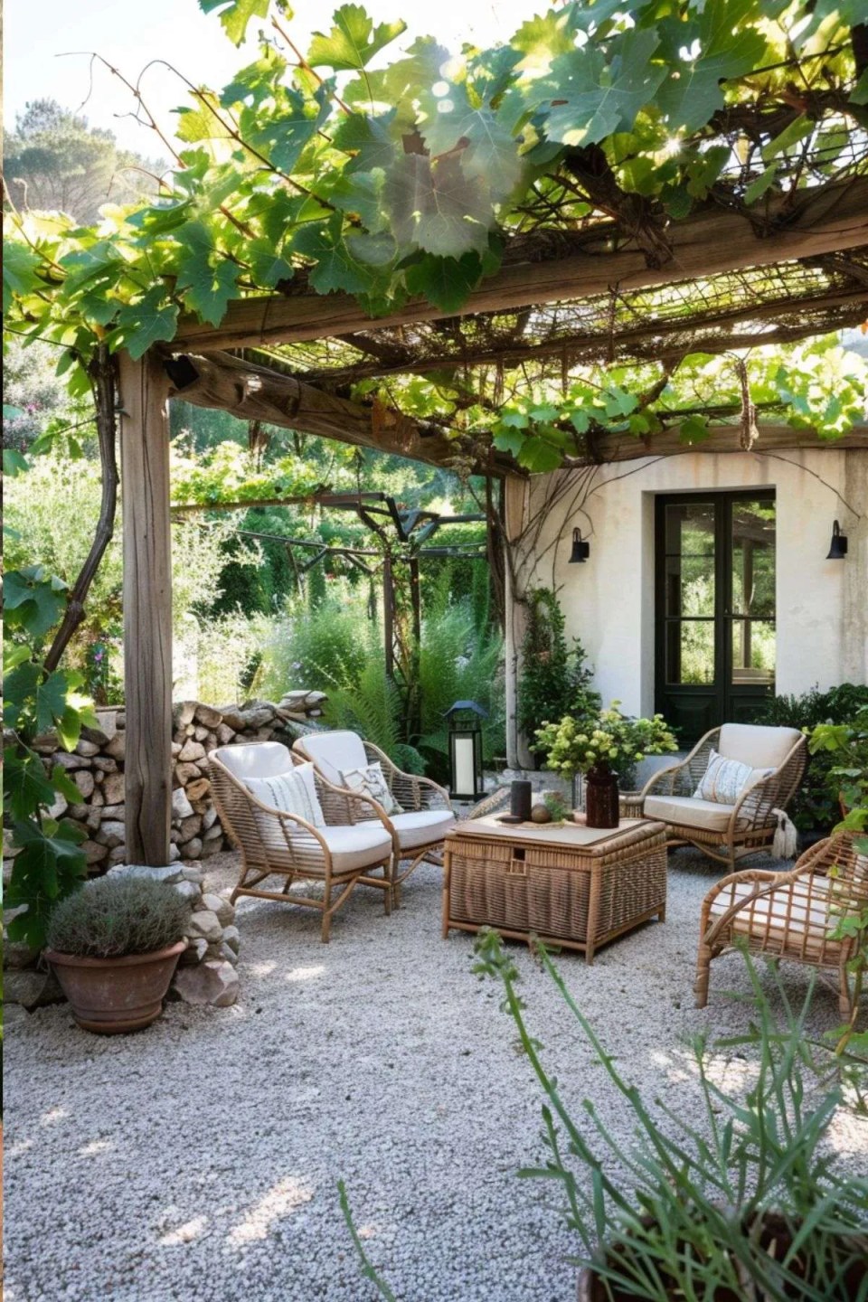 a pergola built on the side of a house with grapevines and rattan furniture