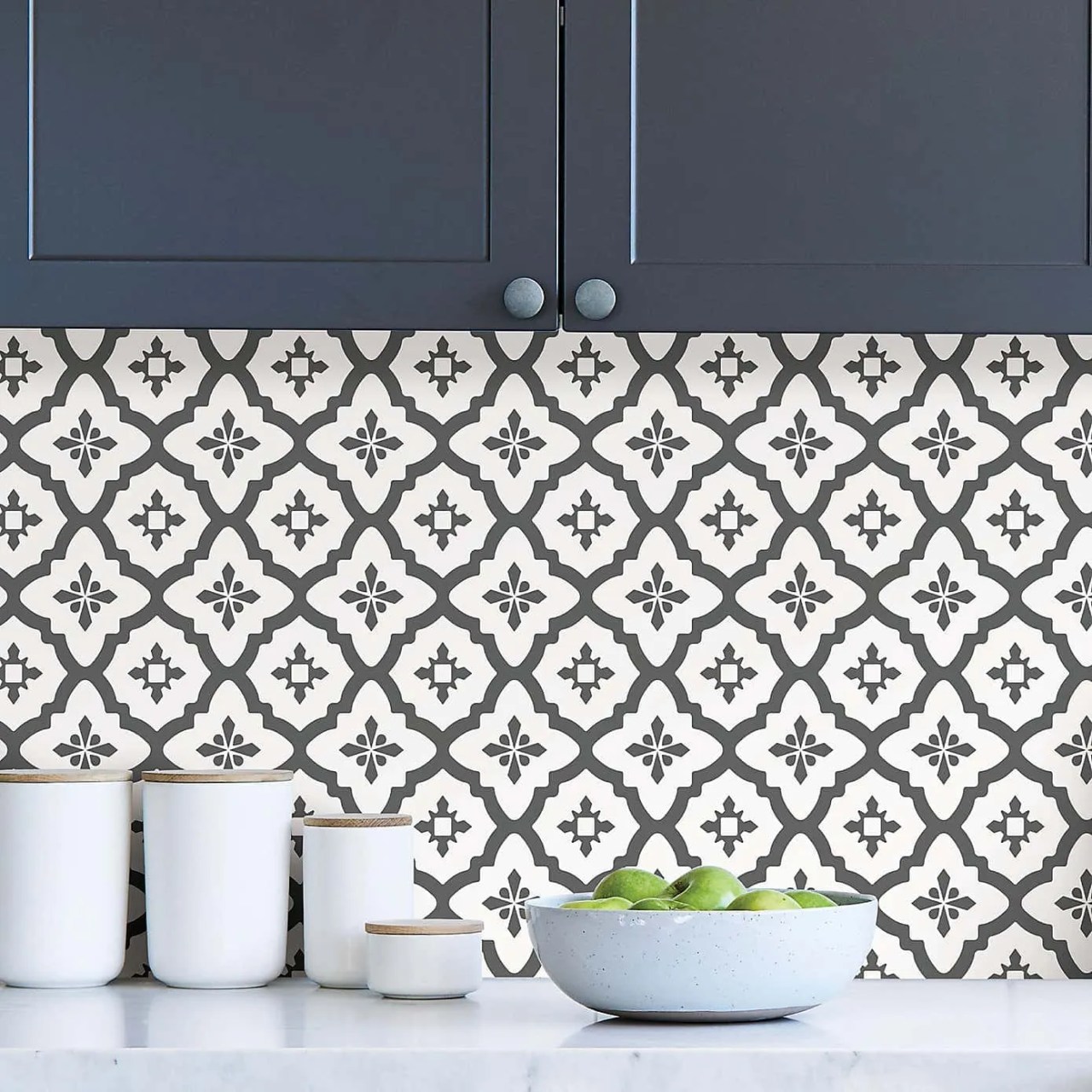 monochrome patterned tiles in the kitchen with dark blue kitchen cabinets