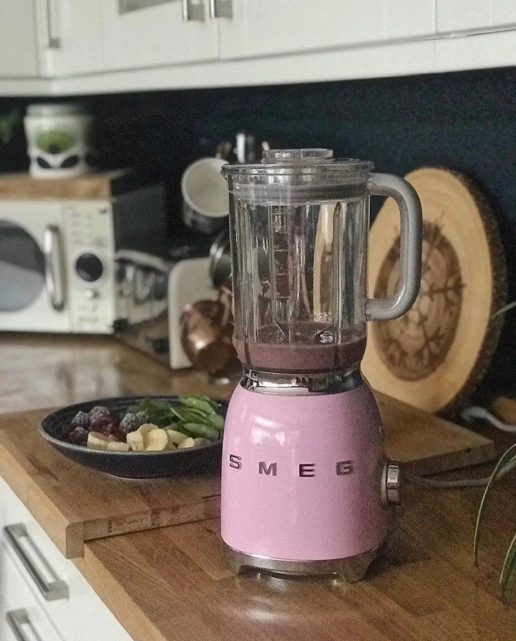 pink smeg food mixer on oak wooden worktops in the kitchen