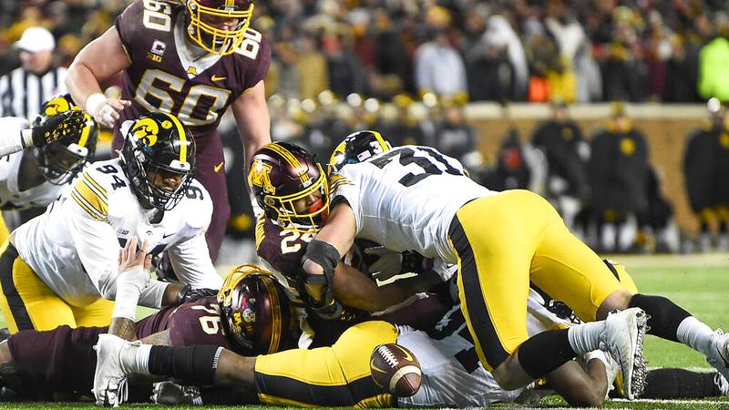 Minnesota running back Mohamed Ibrahim, second from right, fumbles the ball as he is hit by...