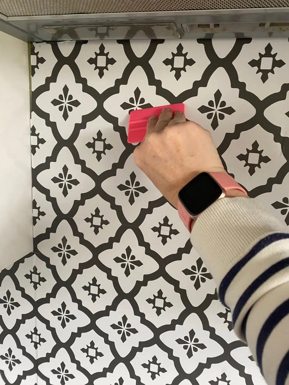 smoothing the wallpaper down 