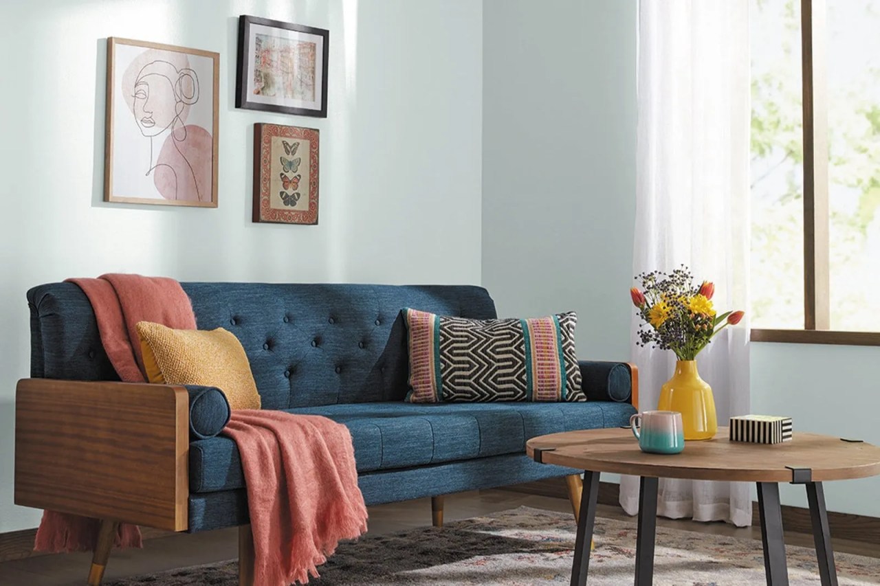 denim blue sofa and pale blue walls with pops of yellow and red